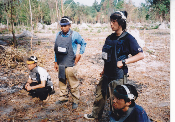 カンボジアの地雷原を見学する大学４年生の時の鬼丸さん（右下）