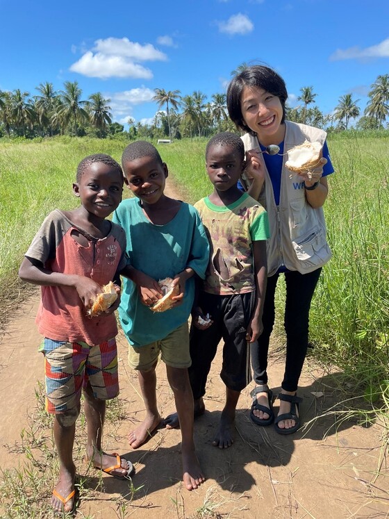モザンビークの田舎で移動中にココナッツを買い、近くにいた子どもたちと分けつつ会話を楽しむ様子（2022年）。