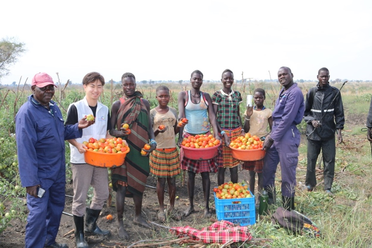 灌漑農業を通して、トマトを収穫できた住民と筆者